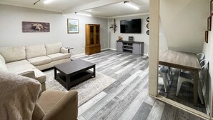 Un salon avec un canapé, une table basse et un meuble pour la télévision.