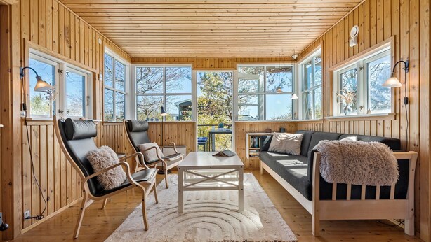 A cozy wooden cabin interior with a sofa, chairs, and a table. - 3 bedroom beautiful home in Grenaa (Grenaa)