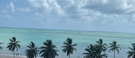 Am Strand, weißer Sandstrand, Liegestühle, Sonnenschirme
