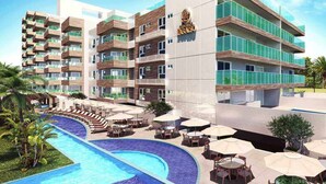 A modern hotel with multiple balconies, a swimming pool, and outdoor seating areas. - Apto pé na areia Ponta de Campina-PB (Cabedelo)