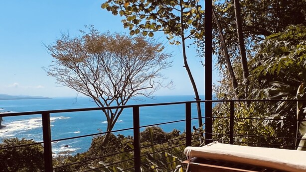 A deck with a view of the ocean, a lounge chair, and a wooden railing. - VERANERA, bas de villa avec vue magnifique sur le pacifique (Puntarenas Province)