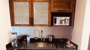 A compact kitchen with wooden cabinets, a built-in microwave, a coffee maker, and a dishwasher. - VERANERA, bas de villa avec vue magnifique sur le pacifique (Puntarenas Province)