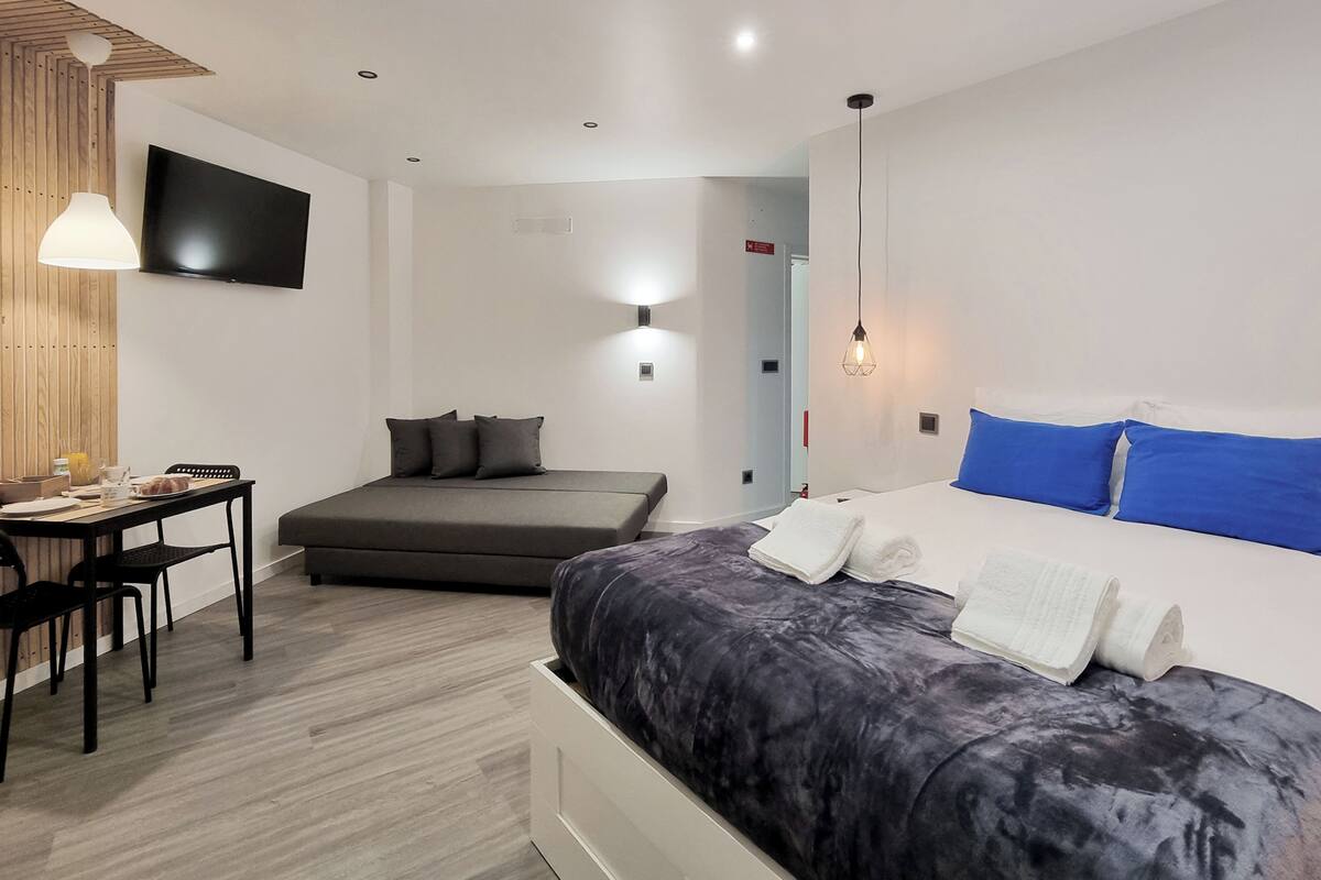 Une chambre d’hôtel moderne équipée d’un lit, d’un canapé, d’un bureau et d’une télévision.