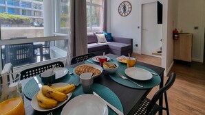 A dining area with a table set for breakfast, including plates, cutlery, and a bowl of bananas.