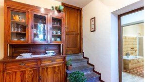 A wooden cabinet with glass doors containing dishes and glassware.