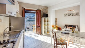 A modern kitchen with a view of a mountainous landscape through an open door.