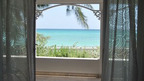 Una habitación con vista al océano a través de una ventana con marco decorativo.