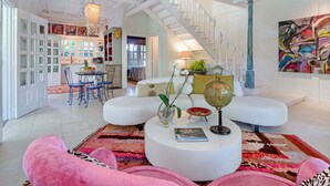 A spacious living room with a high ceiling, a staircase, a dining area, and a kitchen. - Casa Agogó - Carribean house/pool/steps from beach (Puerto Viejo de Talamanca)