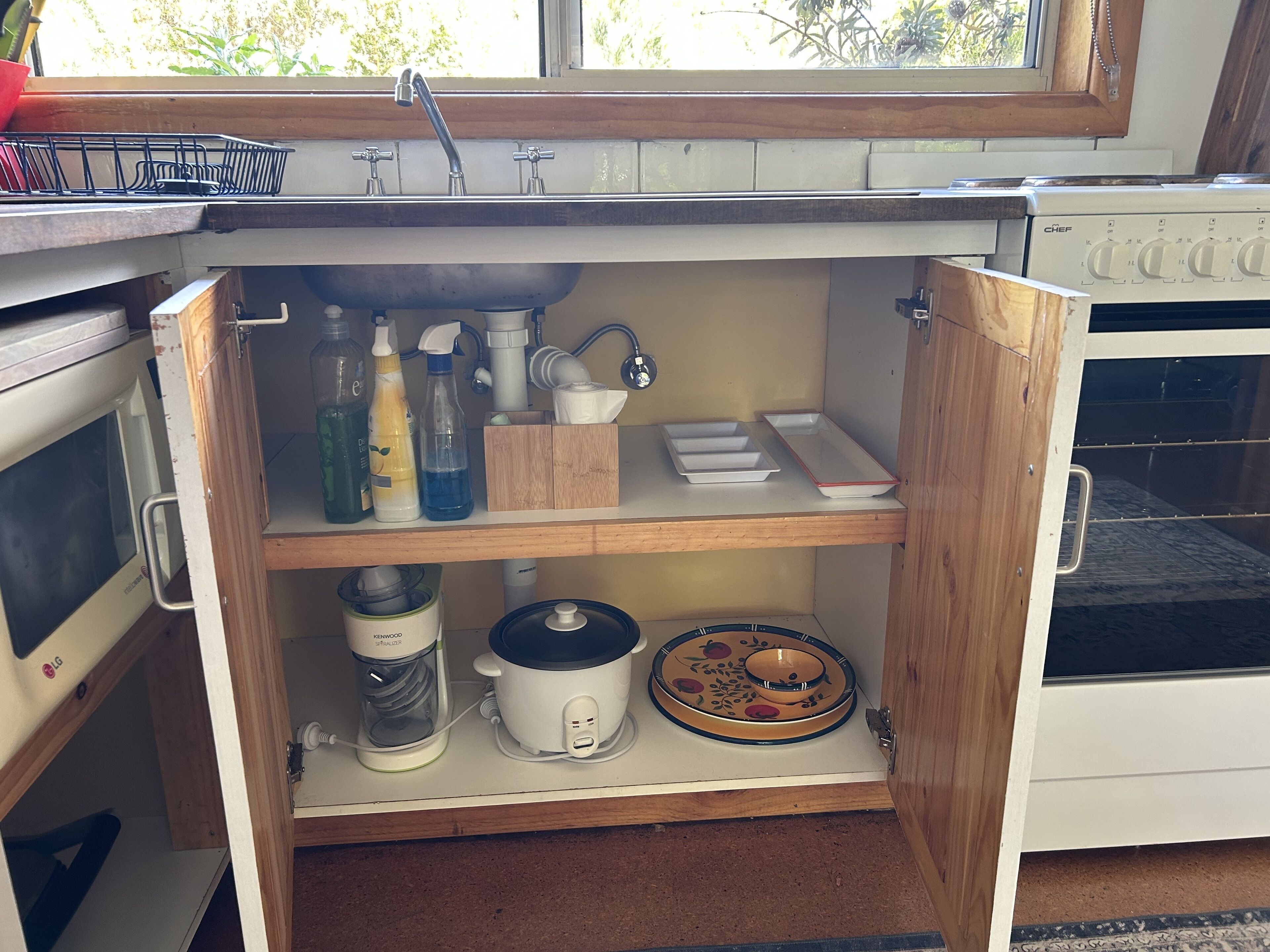 Uma cozinha com forno embutido, máquina de café e escorredor de louça.