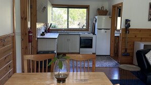 A spacious kitchen with wooden cabinets, a large window, and a dining area with a table and chairs.