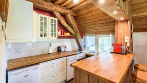 Eine rustikale Küche mit Holzbalken, weißen Schränken und einer Holzausziehtafel.