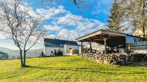 A modern house with a covered porch and a stone wall. - Beautiful home in Nimsreuland with WiFi (Nimsreuland)