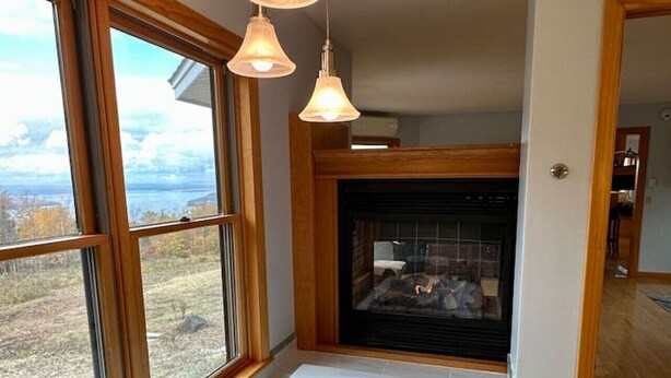 Un baño con una bañera grande, una chimenea y ventanas amplias.