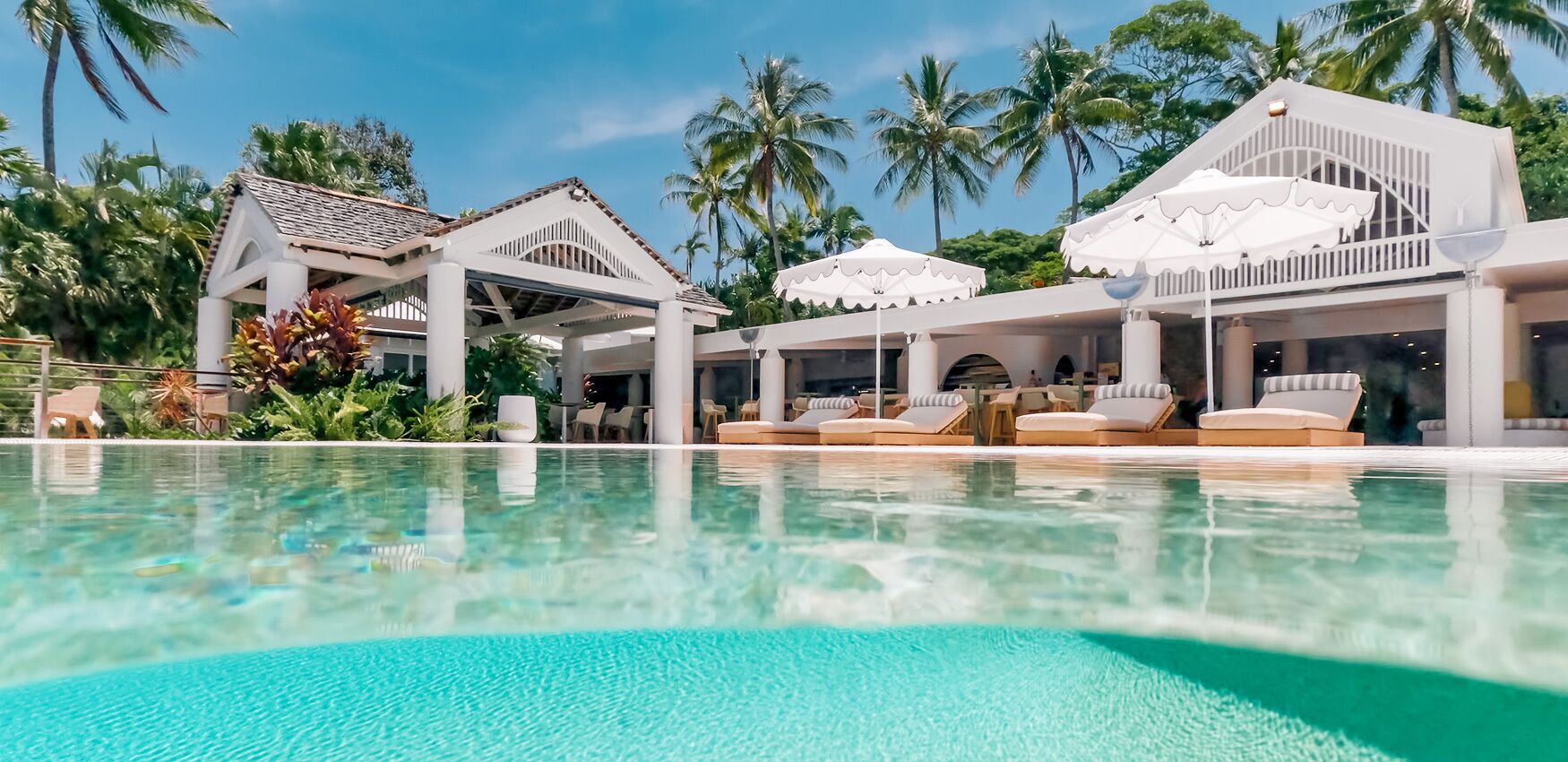 Een resort met een zwembad, ligbedden en parasols.