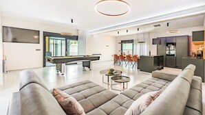 A modern living room with a pool table, a sofa, and a dining area. - Amazing home in Fazana with sauna (Fazana)