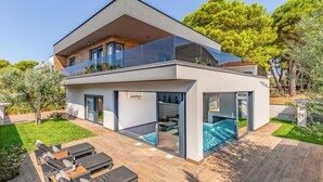 A modern two-story house with a large glass balcony, a swimming pool, and outdoor seating. - Amazing home in Fazana with sauna (Fazana)