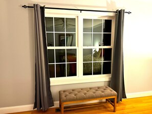 Ein Zimmer mit Fenster, einer Bank und einem Bett.