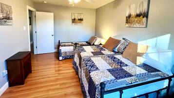 A bedroom with a bed, a ceiling fan, and artwork on the walls.