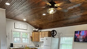 A cozy living room with a wooden coffee table, a blue sofa, and a rustic rug. - Casa Azul - Cozy cabin centrally located downtown Bandera (Bandera)