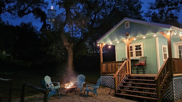 A cabin with a deck, outdoor seating, and a fire pit. - Casa Azul - Cozy cabin centrally located downtown Bandera (Bandera)