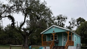 A small, single-story house with a porch and outdoor seating area. - Casa Azul - Cozy cabin centrally located downtown Bandera (Bandera)