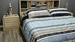 Een slaapkamer met een bed, nachtkastjes en kunst aan de muur.