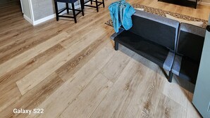 Una cocina moderna con armarios blancos, una isla central y un comedor con sillas.