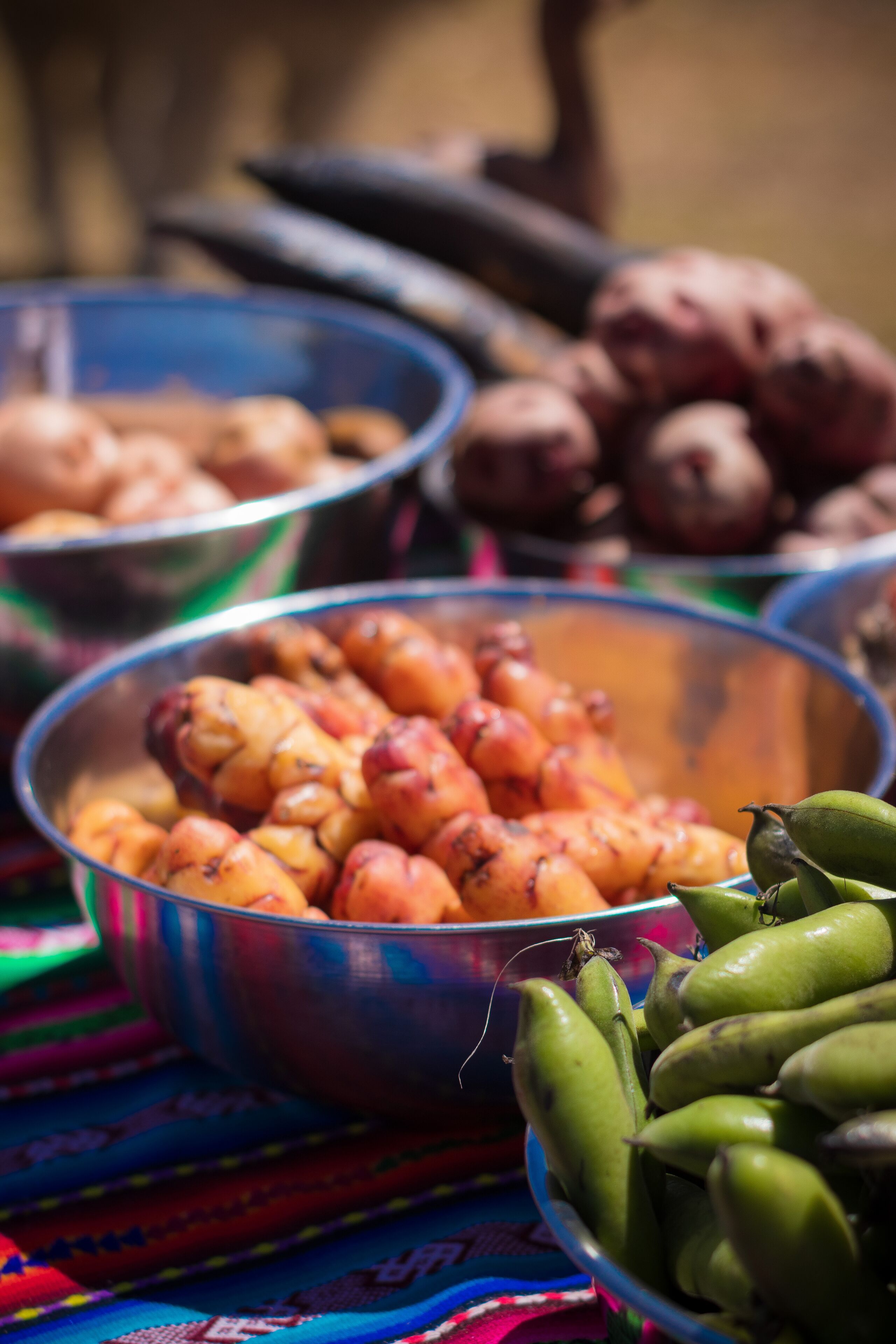 Una mesa con recipientes llenos de comida, incluyendo aparentemente patatas asadas y judías verdes.
