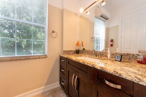 Bathroom features a large mirror, granite sink, and dark cabinets with silver handles.
