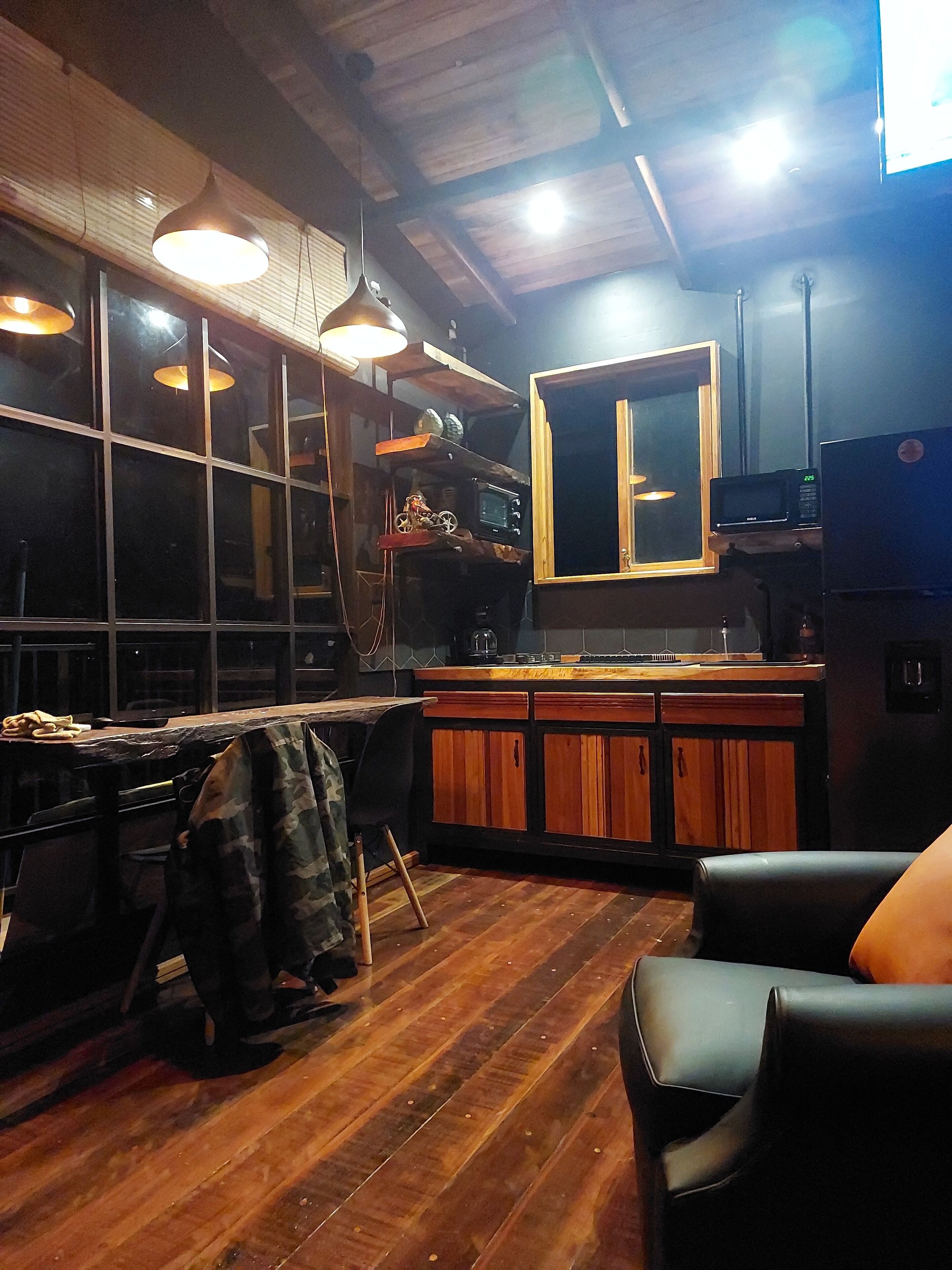 A cozy kitchen with wooden cabinets, a dining table, and a large window.