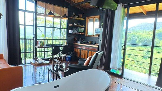 A modern bathroom with a freestanding bathtub, a large window with a view of the outdoors, and a wooden ceiling. - Sitting on stilts, Stuido Wow has spectacular volcano, lake & rain forest views! (El Castillo)