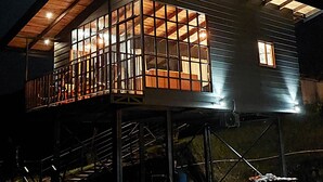 A two-story house with a balcony and a covered porch area. - Sitting on stilts, Stuido Wow has spectacular volcano, lake & rain forest views! (El Castillo)
