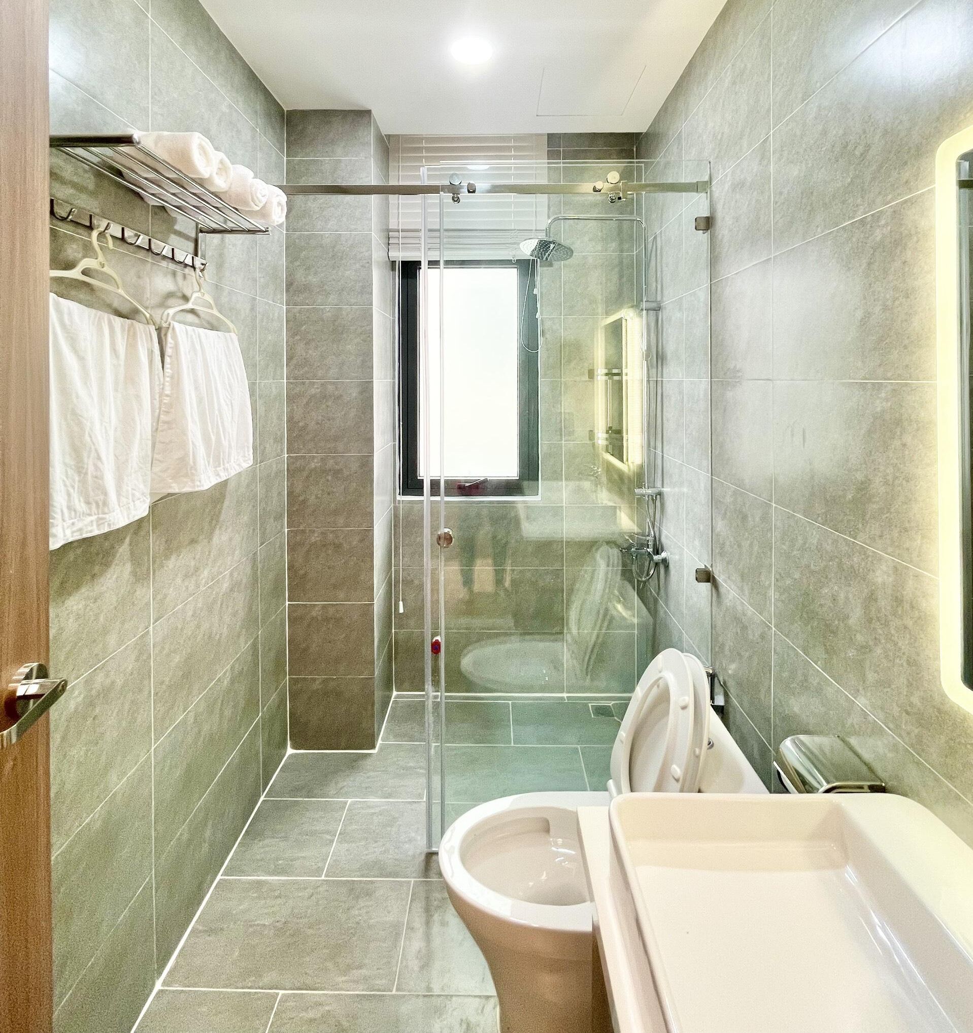 Un baño moderno con ducha de vidrio, inodoro y lavamanos.