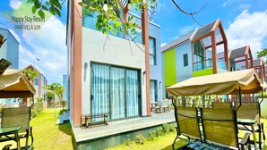 A modern resort with a patio area, outdoor seating, and a pool. - Happy Stay Resort (Ho Chi Minh City)