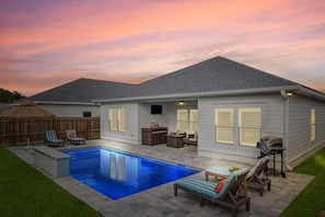 A house with a swimming pool, patio furniture, and a barbecue grill. - Sunset Haven by the Pool (Panama City Beach)