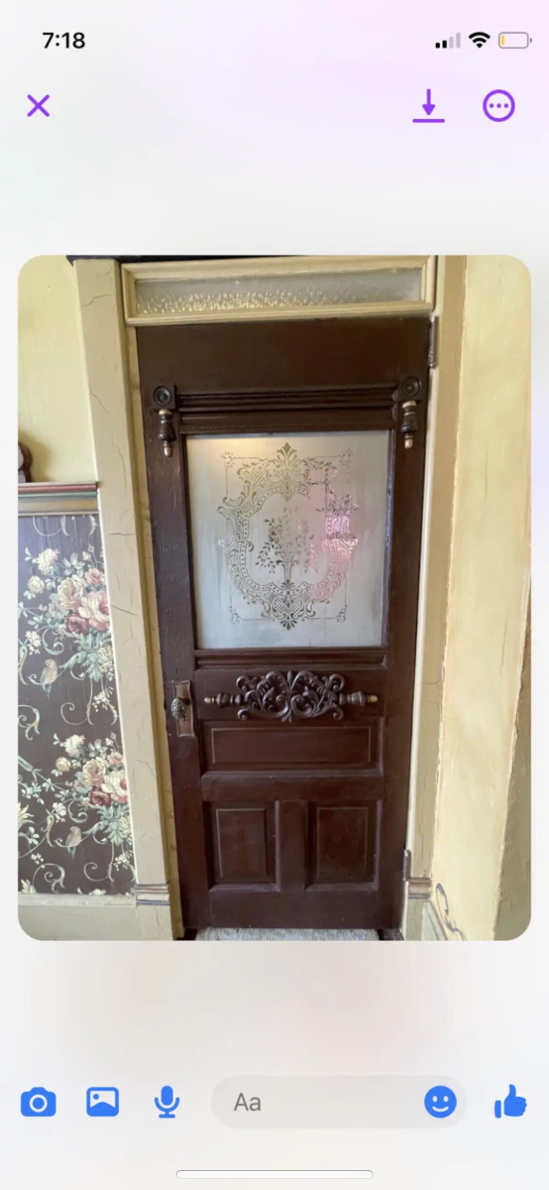A wooden door with a decorative glass panel and a metal handle.
