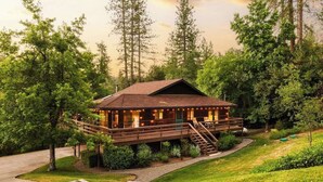 A lodge with a wooden deck, a covered porch, and a staircase leading to the main building.