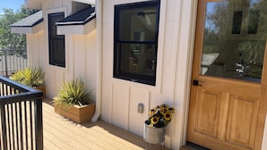 A house with a wooden deck, a front door, and two windows. - Old Town Oasis - the perfect 30 day stay (Fort Collins)