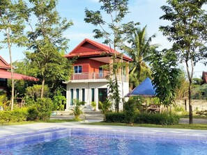 A hotel with a pool, surrounded by lush greenery and palm trees. - Kampot Nature Villa Resort (Kampot)
