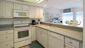 A kitchen with white cabinets, a microwave, an oven, and a sink. - Bayfront 2br Siesta Key condo with beach access - GBB 1382 (Sarasota)