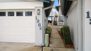 A residential property with a white garage, a staircase leading to a covered porch, and a number '1382' on the wall. - Bayfront 2br Siesta Key condo with beach access - GBB 1382 (Sarasota)