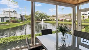A dining area with a view of a water canal, a house, and a fountain. - Lakefront Siesta Key condo with beach access - GBB 1313 (Sarasota)