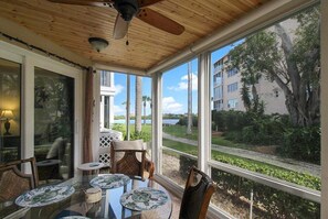 Una veranda luminosa con ampie finestre, una ventola a soffitto e un tavolo con sedie.