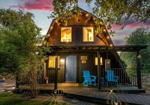 Eine Holzhütte mit Veranda, zwei Fenstern und einer Tür.
