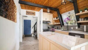 Una cocina moderna con armarios de madera, encimera de mármol y horno empotrado.