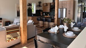 Eine moderne Küche mit Holzschränken, einer großen Kochinsel und Pendelleuchten.