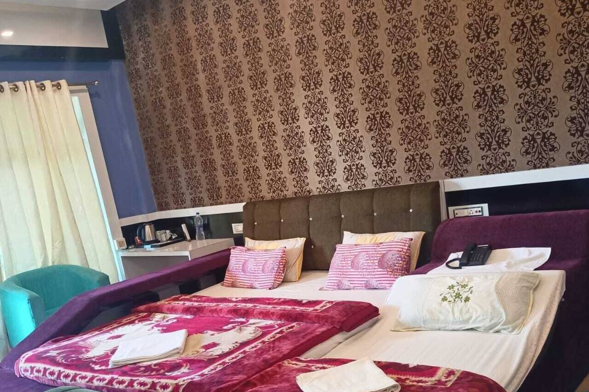 Quarto bem equipado com uma cama grande, cabeceira e mesa de cabeceira com abajur.