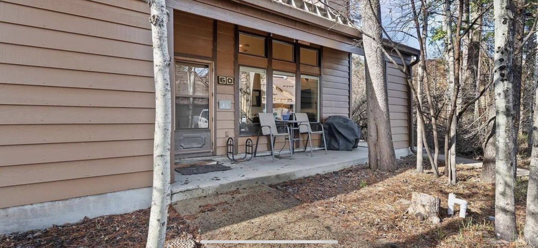 A building with a porch, a number '60' sign, and outdoor seating.
