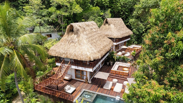 A resort with two thatched-roof villas, a pool, and lush tropical surroundings. - Tewimake Hotel  (Santa Marta)