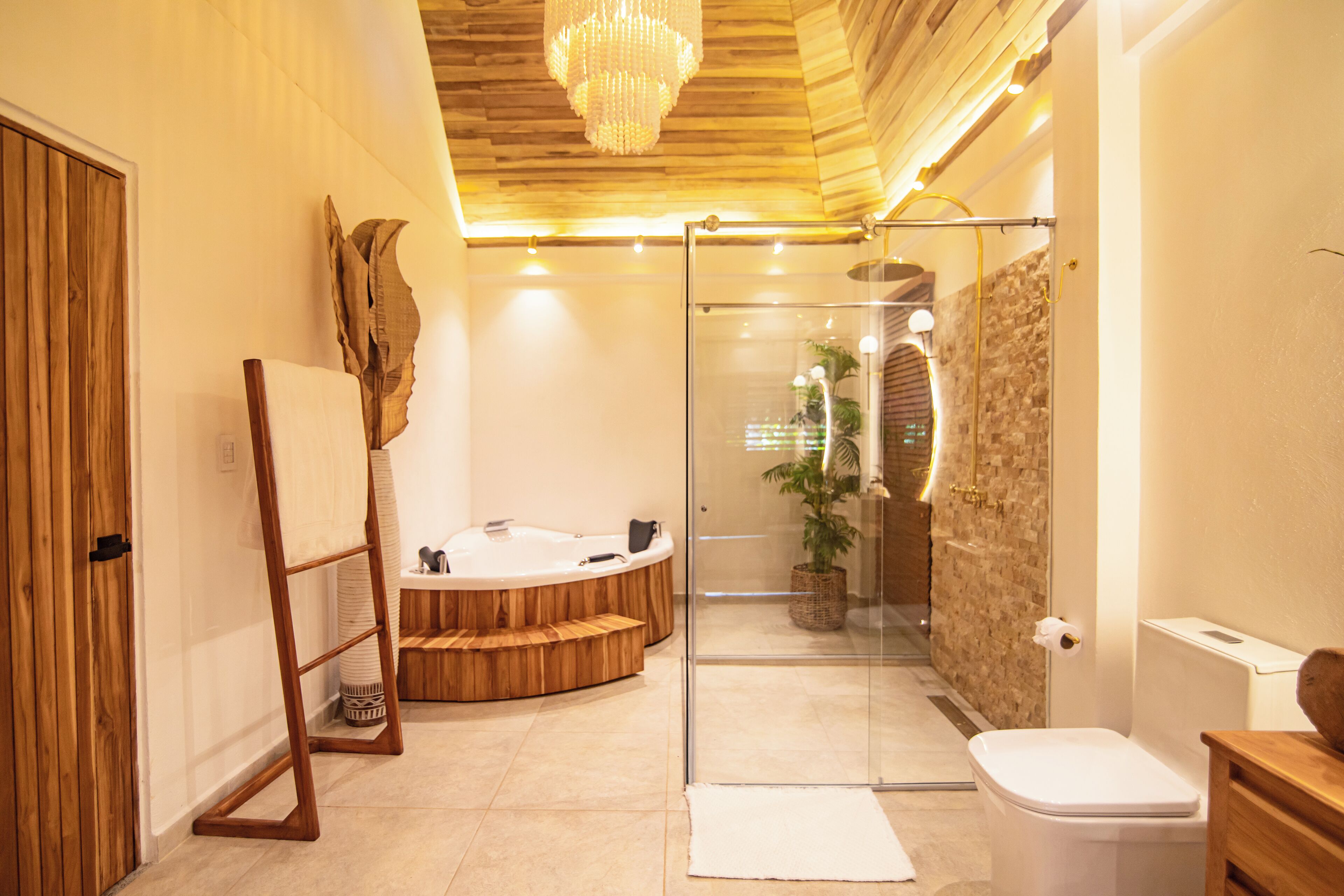 A modern bathroom with a glass-enclosed shower, a wooden vanity, and a freestanding bathtub.